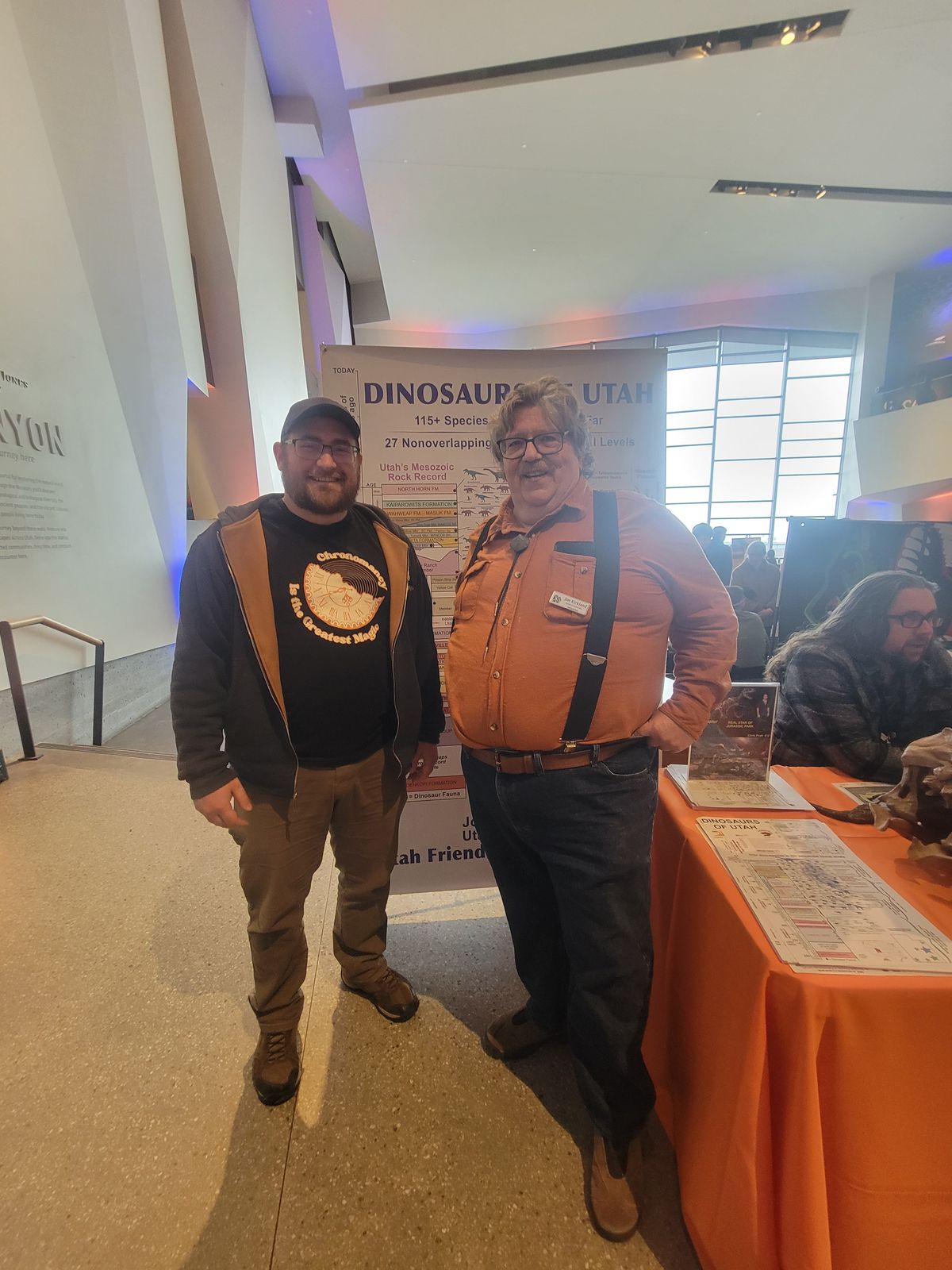 A picture of two men standing in front of a Dinosaurs of Utah poster.